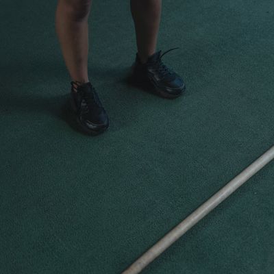 Close up of sports shoes on a dark textured floor.