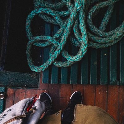 Jump rope coiled neatly on a dark wooden bench.