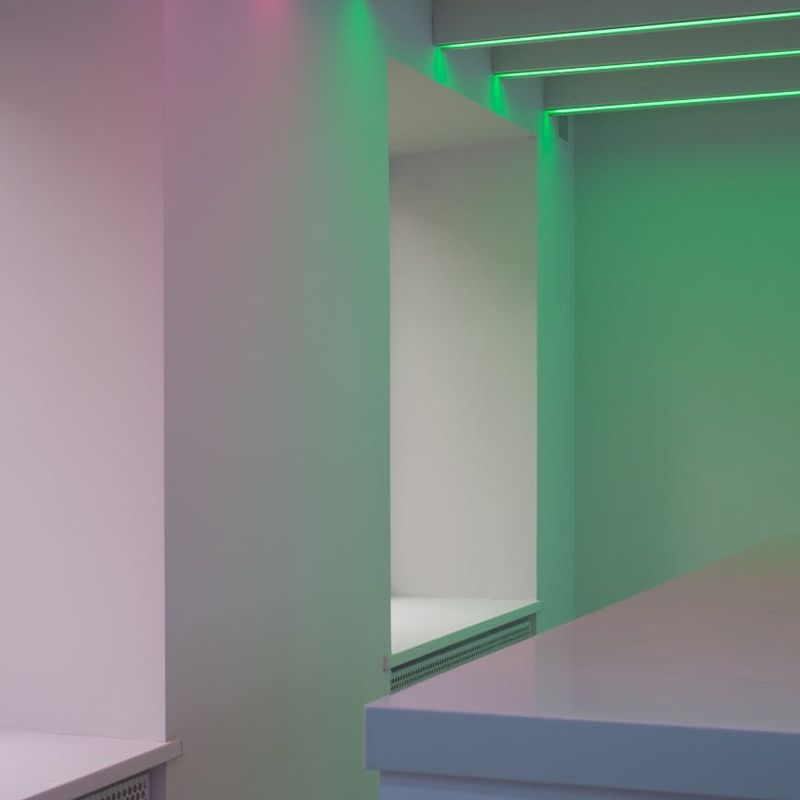 Modern minimalist gym interior with neon pink lighting accents.