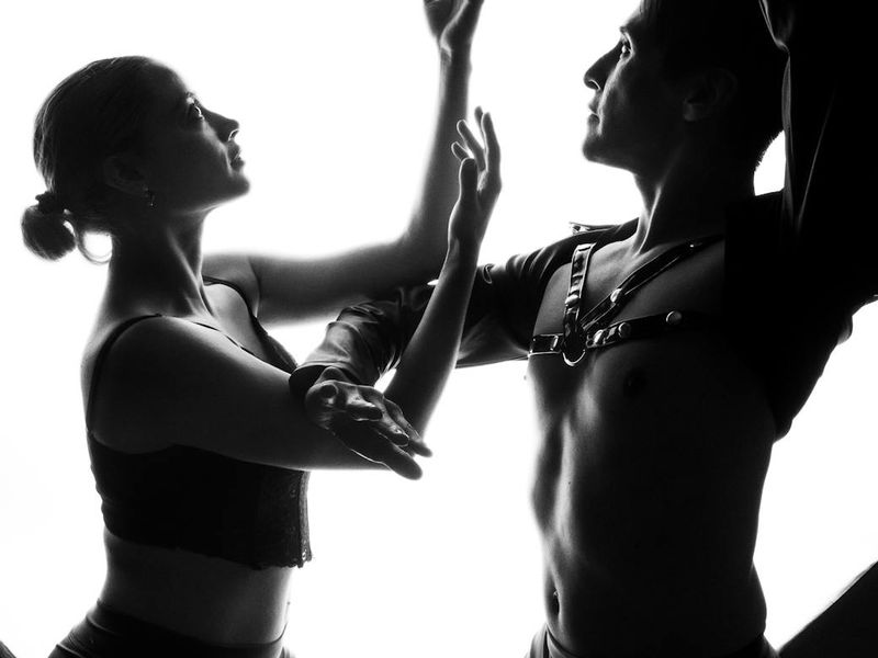 Silhouette of person performing fluid movements against dark background.