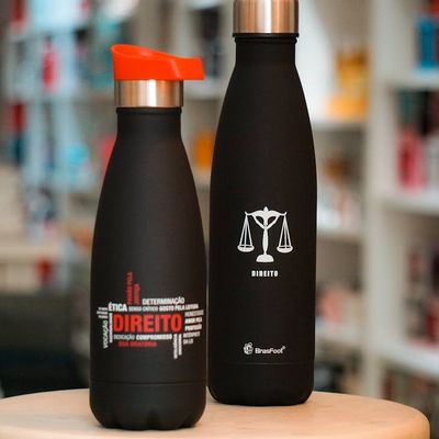 Stainless steel water bottle standing on a fitness mat.